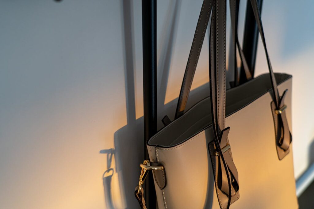 High-quality leather handbag elegantly hanging on a wall with soft lighting.