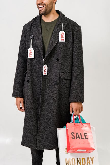 A fashionable man holding shopping bags with sale tags on a chic winter coat, embracing holiday deals.